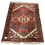 Persian design red ground rug, with stylised geometric and floral decoration on red field, 112cm x 1