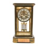 Late 19th century brass and four glass presentation clock, with white enamel dial and Roman numeral