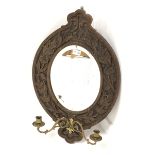 20th century oak framed wall mirror, with floral carved frame enclosing bevelled plate, and two bras