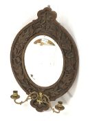 20th century oak framed wall mirror, with floral carved frame enclosing bevelled plate, and two bras