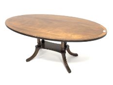 20th century mahogany coffee table, oval cross banded top, four pillar on platform with reeded out s