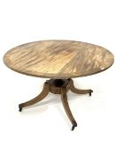 Regency mahogany circular tilt top dining table with crossbanded border on a vase turned column and