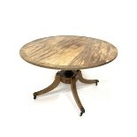 Regency mahogany circular tilt top dining table with crossbanded border on a vase turned column and