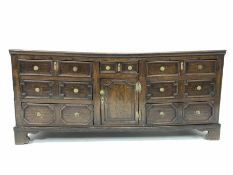 18th century country oak dresser, with seven geometric panelled drawers and a cupboard, raised on sh