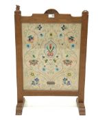 'Squirrelman' Yorkshire oak fire screen, adzed frame enclosing glazed needlework panel, raised on ar