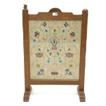 'Squirrelman' Yorkshire oak fire screen, adzed frame enclosing glazed needlework panel, raised on ar