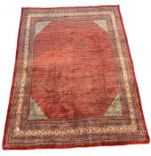 Large Persian Araak carpet, red ground field decorated all over with Boteh motifs, multiple band bor