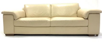 Natuzzi contemporary three seat sofa, upholstered in cream faux leather, raised on walnut block supp
