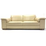 Natuzzi contemporary three seat sofa, upholstered in cream faux leather, raised on walnut block supp