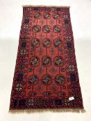 Eastern red ground rug, with repeating gul motif on red field, 100m x 212cm