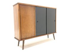 Mid 20th century teak and oak sideboard or bookcase, fitted with three sliding doors enclosing adjus