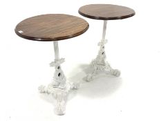 Pair of Victorian design cast iron tables, with circular mahogany tops raised on raised in column an