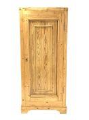 Large pine cupboard, with single fielded panelled door enclosing a shelf, raised on bracket supports