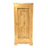 Large pine cupboard, with single fielded panelled door enclosing a shelf, raised on bracket supports