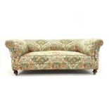 20th century drop arm chesterfield two seat sofa, upholstered in floral linen, and raised on front