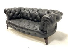 19th century chesterfield two seat drop arm sofa, upholstered in buttoned black leather, raised on m