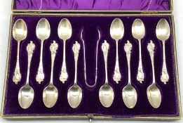 Set of twelve Edwardian silver tea spoons with rococo finials and matching tongs