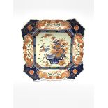 Japanese Meiji period Imari charger of canted square form, painted with a basket of flowers within a