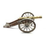 Model of a Louis XIV canon, metal mounted wood carriage with rotating wheels and embossed brass barr