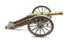 Model of a Louis XIV canon, metal mounted wood carriage with rotating wheels and embossed brass barr