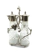 Silver plated two division decanter stand with vine decoration and two glass claret jugs with plated