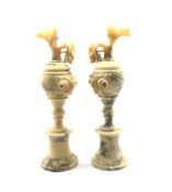 Pair of veined alabaster ewers, the handles modelled as trailing fruiting vines on turned socle base