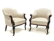 Pair of late Victorian walnut upholstered armchairs, with scrolled arm terminals, raised on floral c