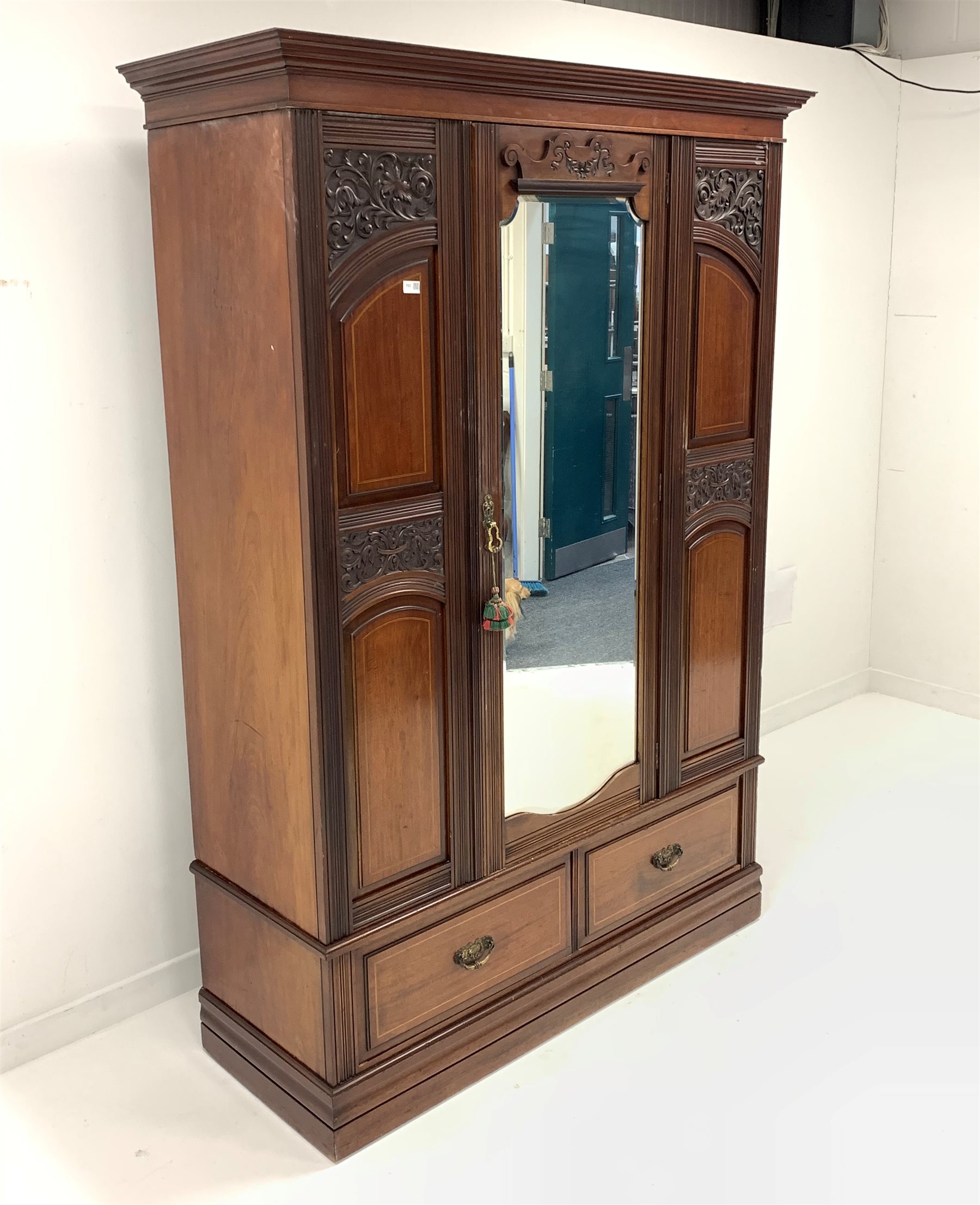 Late Victorian mahogany wardrobe, projecting cornice over panelled and carved front, centre bevelled