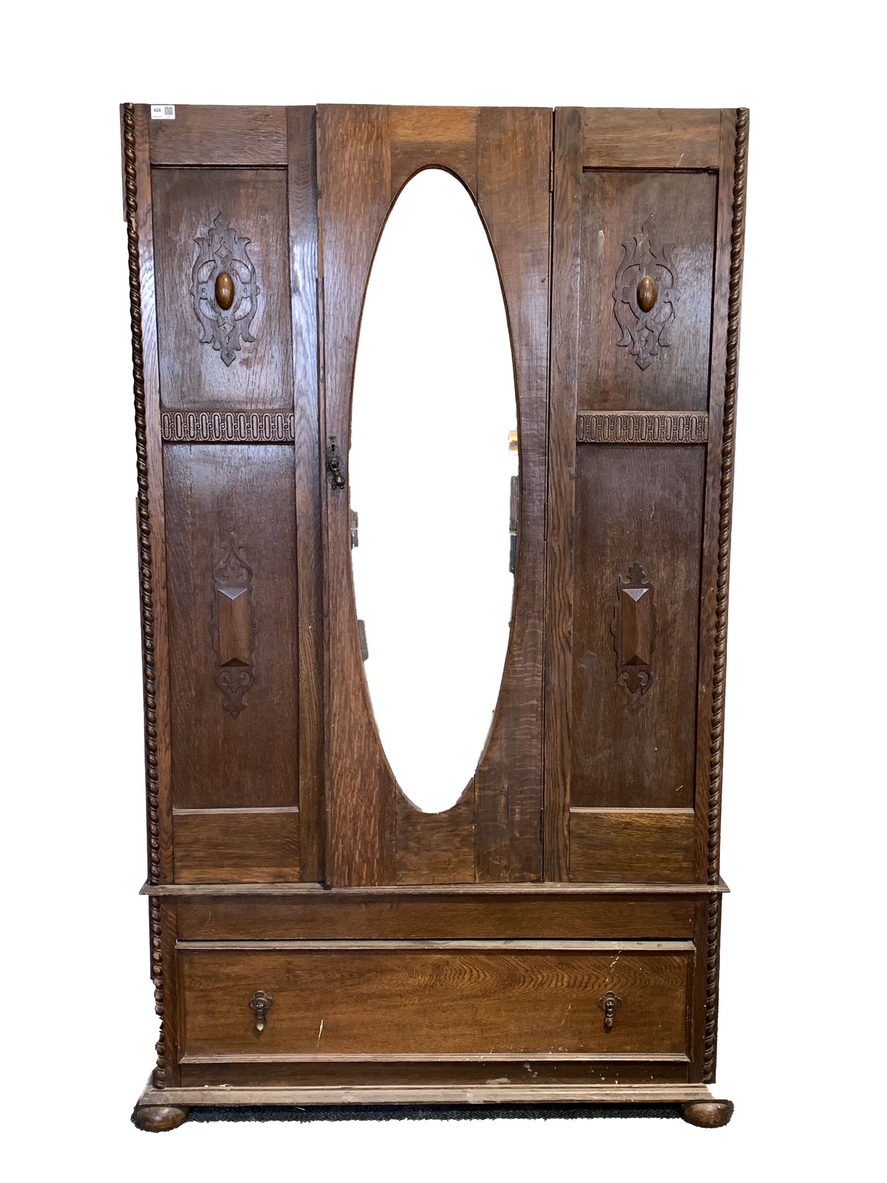 Early 20th century oak single wardrobe, with bevelled oval mirror enclosing interior fitted for hang
