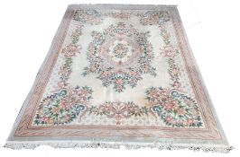 Large Chinese washed wool carpet with floral medallion and spandrels on an ivory field enclosed by b