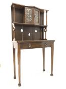 Early 20th century oak Arts and Crafts writing desk, raised back with open shelf and cupboard to cen