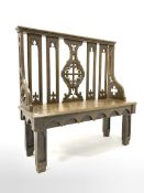 19th century oak hall bench of Gothic design, with arched splats carved with fleur de lis, chamfered