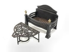 Cast iron fire grate with brass finials, (W50cm) and a 20th century demi lune cast iron footman (W39