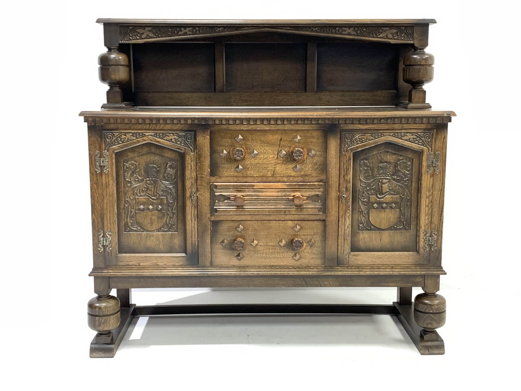 Early 20th century medium oak sideboard, raised back with floral carved frieze, two cupboards under