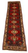 Turkman red ground runner, repeating lozenge medallion, enclosed by border decorated with stylised b