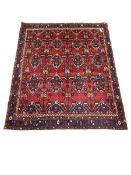 Iranian Neynz rug, red ground with multiple stylised lozenge decorated field