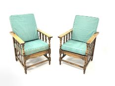 Pair of early 20th century oak reclining tub shaped chairs, upholstered squab cushions, raised on tu