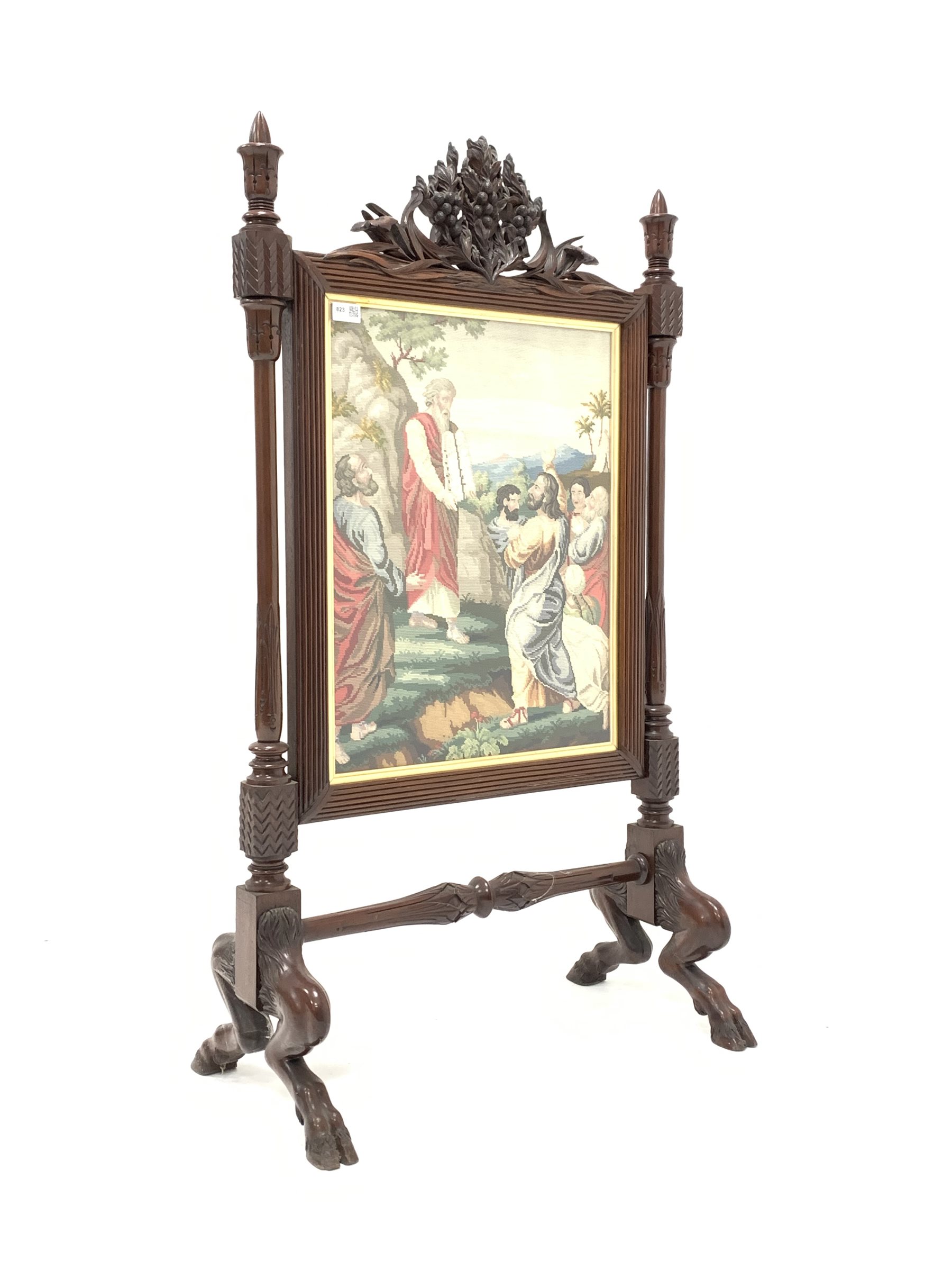 Victorian mahogany fire screen, reeded frame with needlework panel surmounted by floral carved pedim