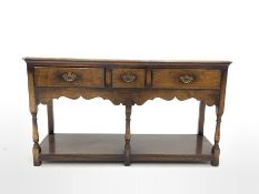 18th century style oak dresser, rectangular moulded top over three drawers, shaped apron, raised on