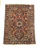 Persian design red ground rug, central medallion on busy field decorated with interlaced and stylise
