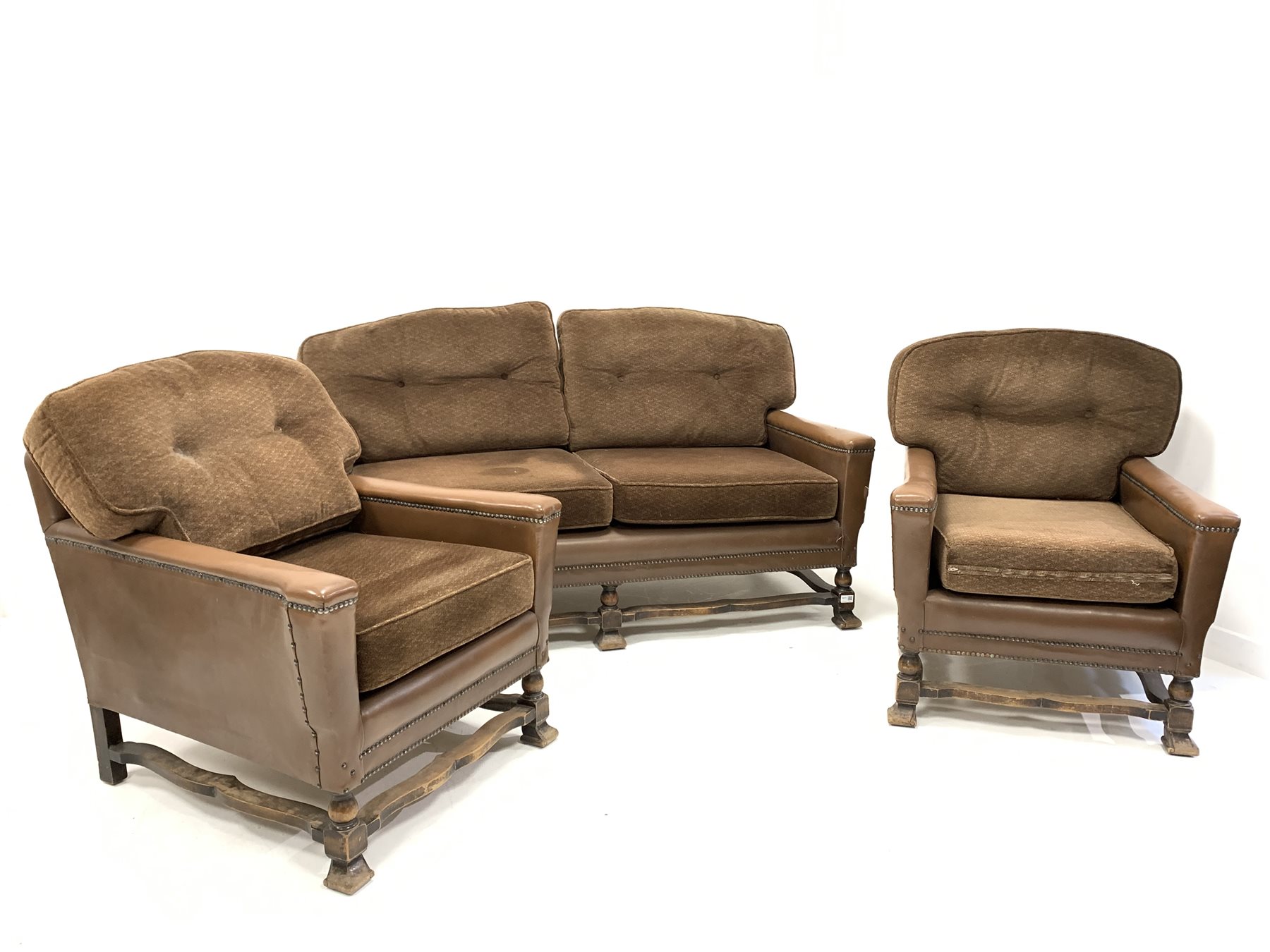 Early 20th century three piece suite, comprising a two seat sofa upholstered in studded leather with