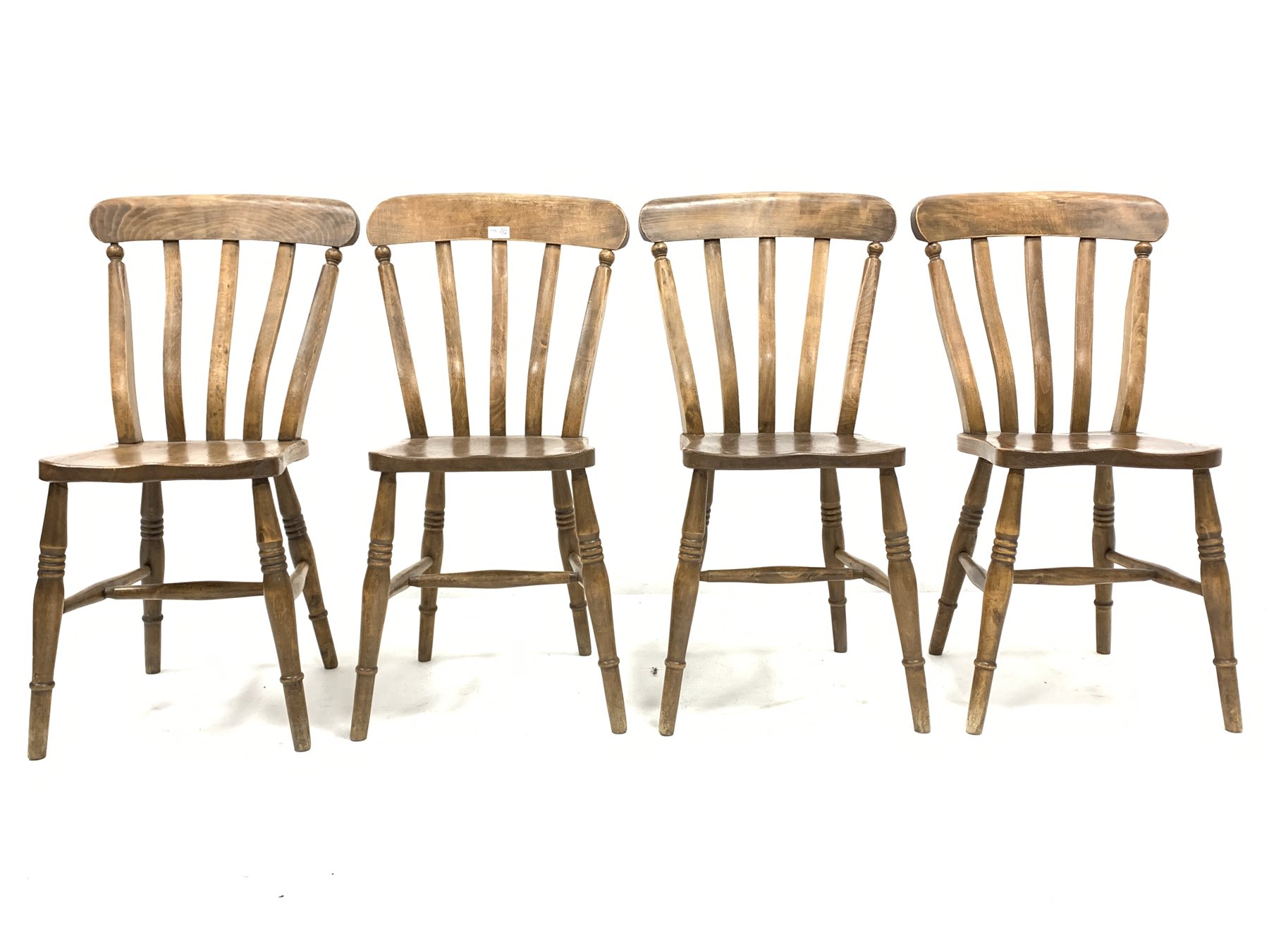 Set of four country elm and beech dining chairs, with shaped seats raised on ring turned supports an