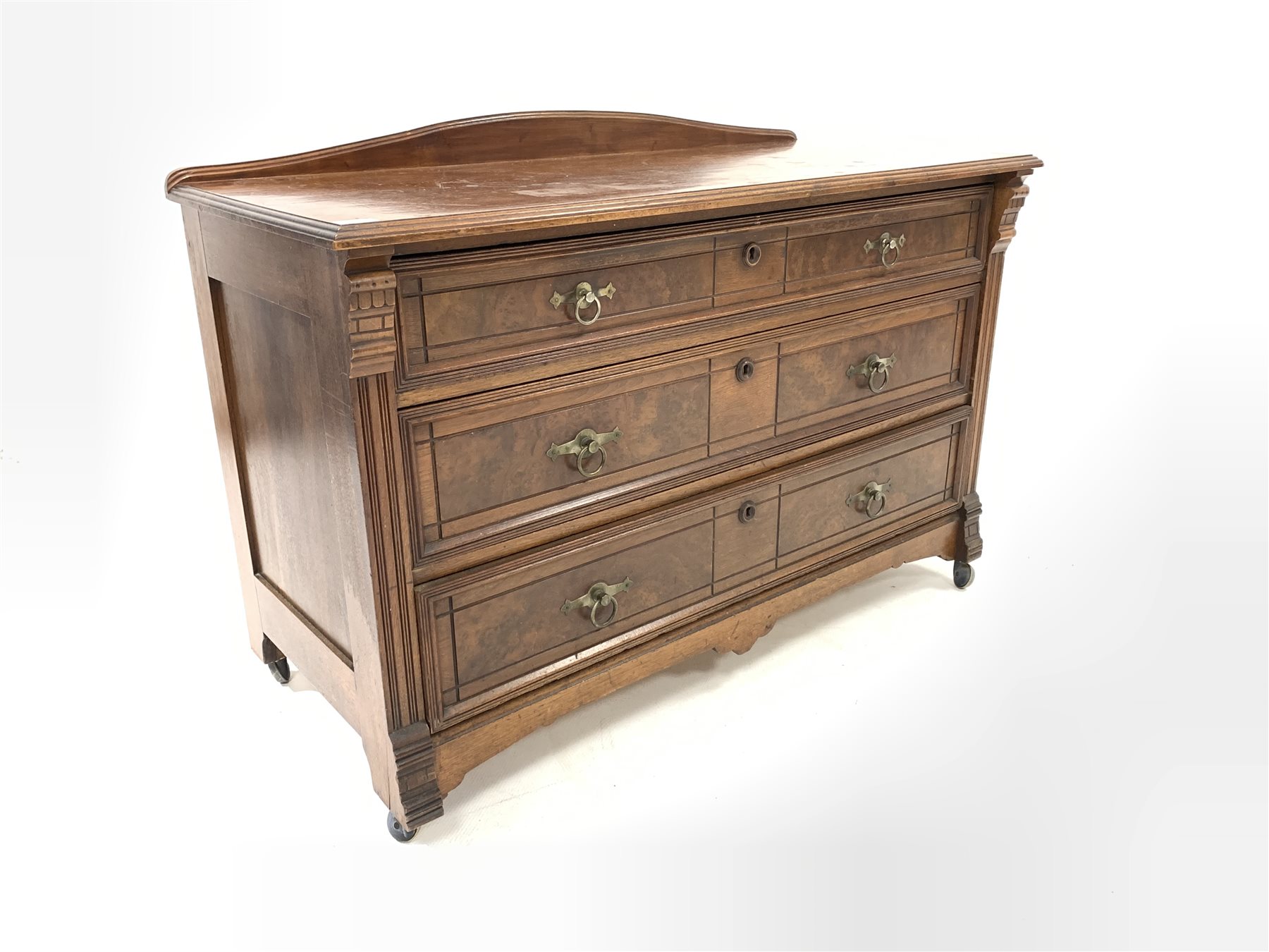 Edwardian walnut chest, with arched raised back and moulded top over three drawers carved with incis