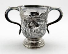 Late George II silver two handled cup engraved with a crest and with a later embossed ploughing sce