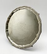 Silver circular salver with gadrooned edge, presentation inscription and on claw and ball feet D31cm