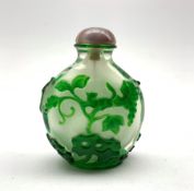 Chinese Peking glass snuff bottle of flat ovoid form, decorated in green glass overlay depicting a s