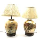 A near pair of glass table lamps having floral decoration on lustre ground, with pleated shades, H66