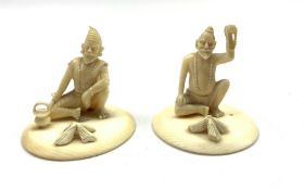 Pair of late 19th/early20th Century Indian carved ivory seated figures of street hawkers on circula