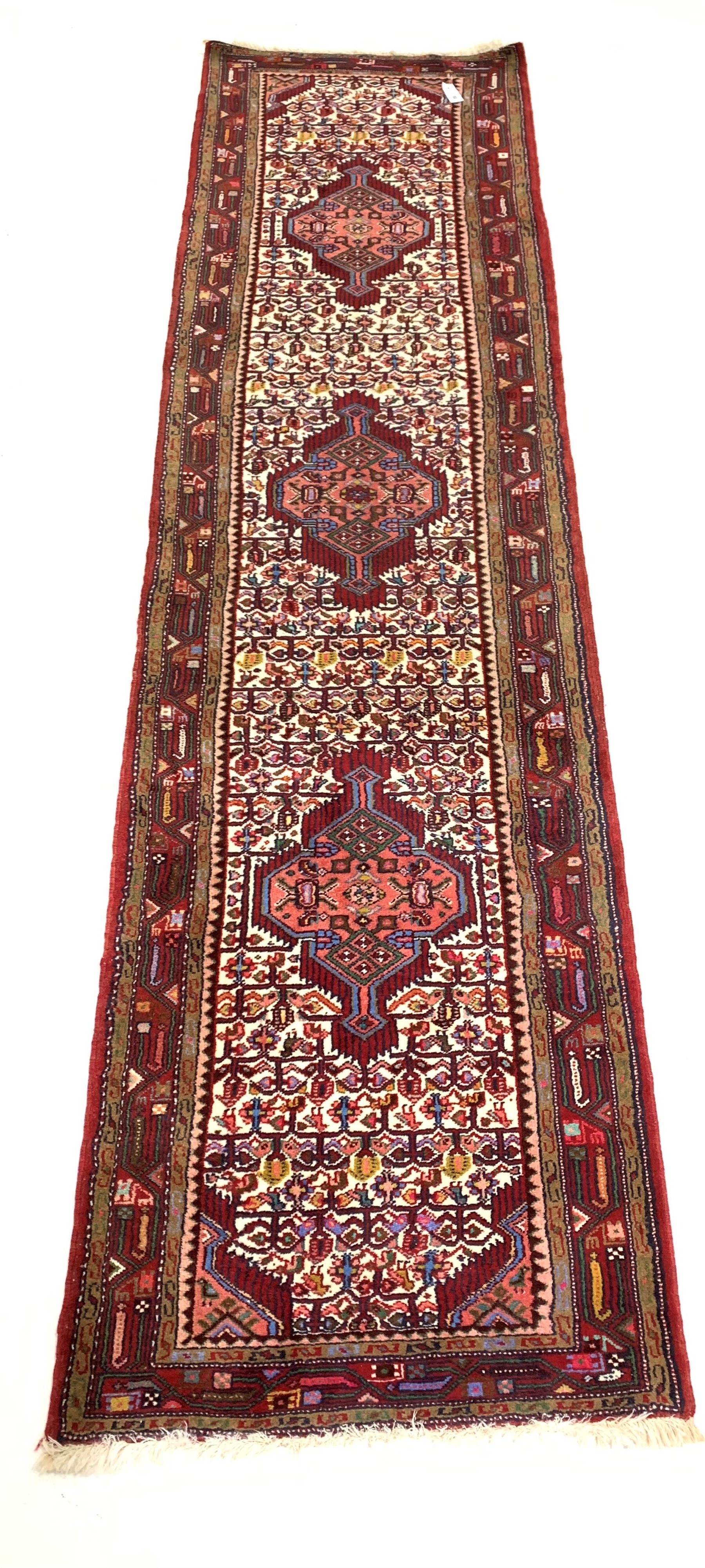 Iranian runner, triple medallion on pale field decorated with repeating motifs