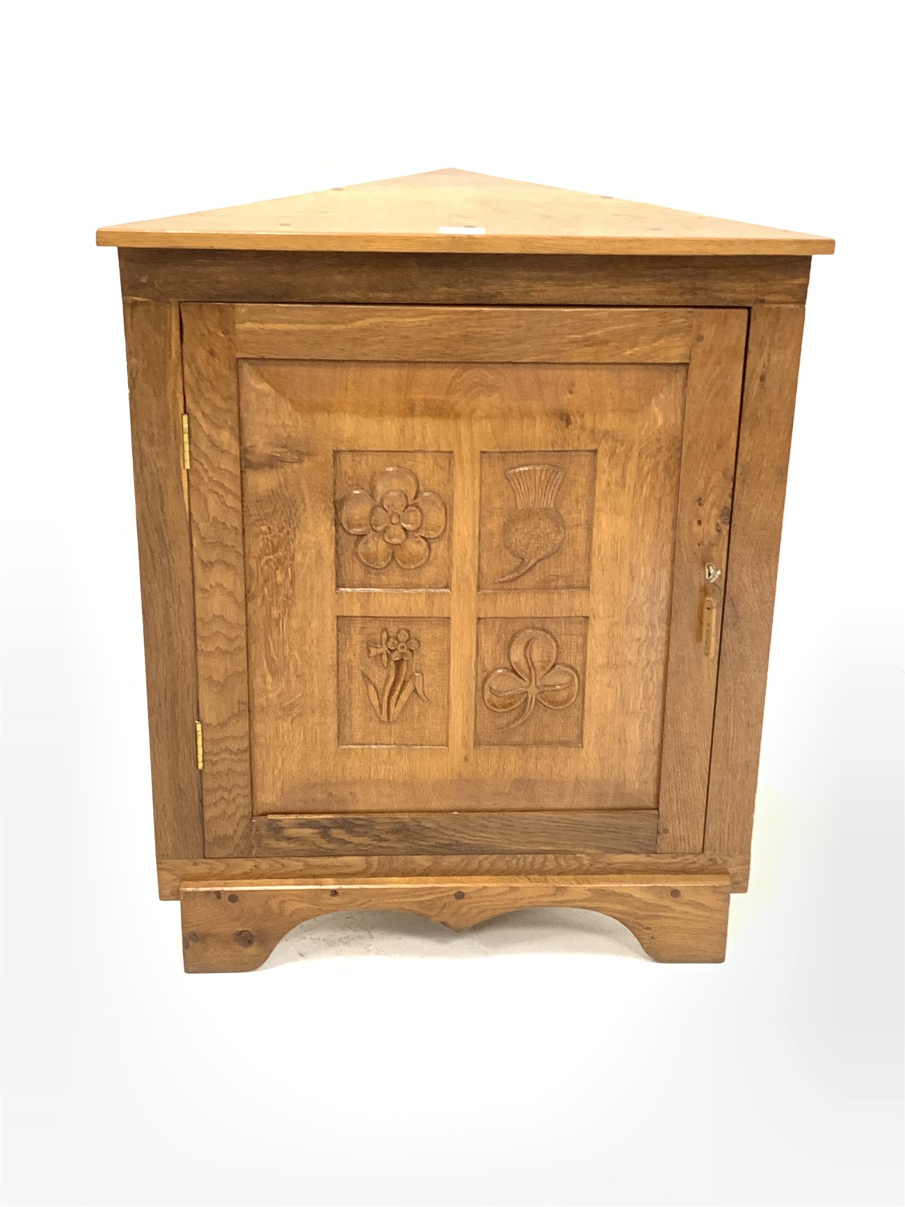 Yorkshire oak floor standing corner cupboard, with sngle fielded panelled door carved with floral de